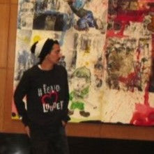 Man wearing black and white Bold Stripe Slouch hat with in a black Urban PentHouse hand painted long sleeve Love Louder tee shirt.