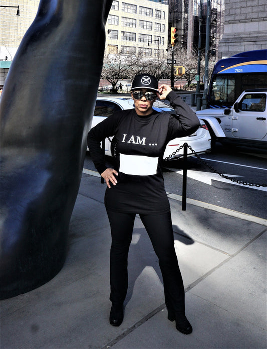 Women wearing long sleeve black Affirm tee shirt, with words I AM printed in white and large white writing block.