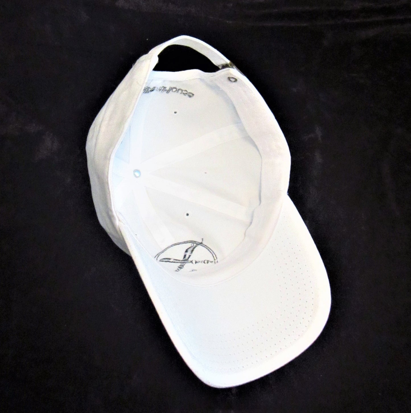 Inside of white baseball cap and visor.