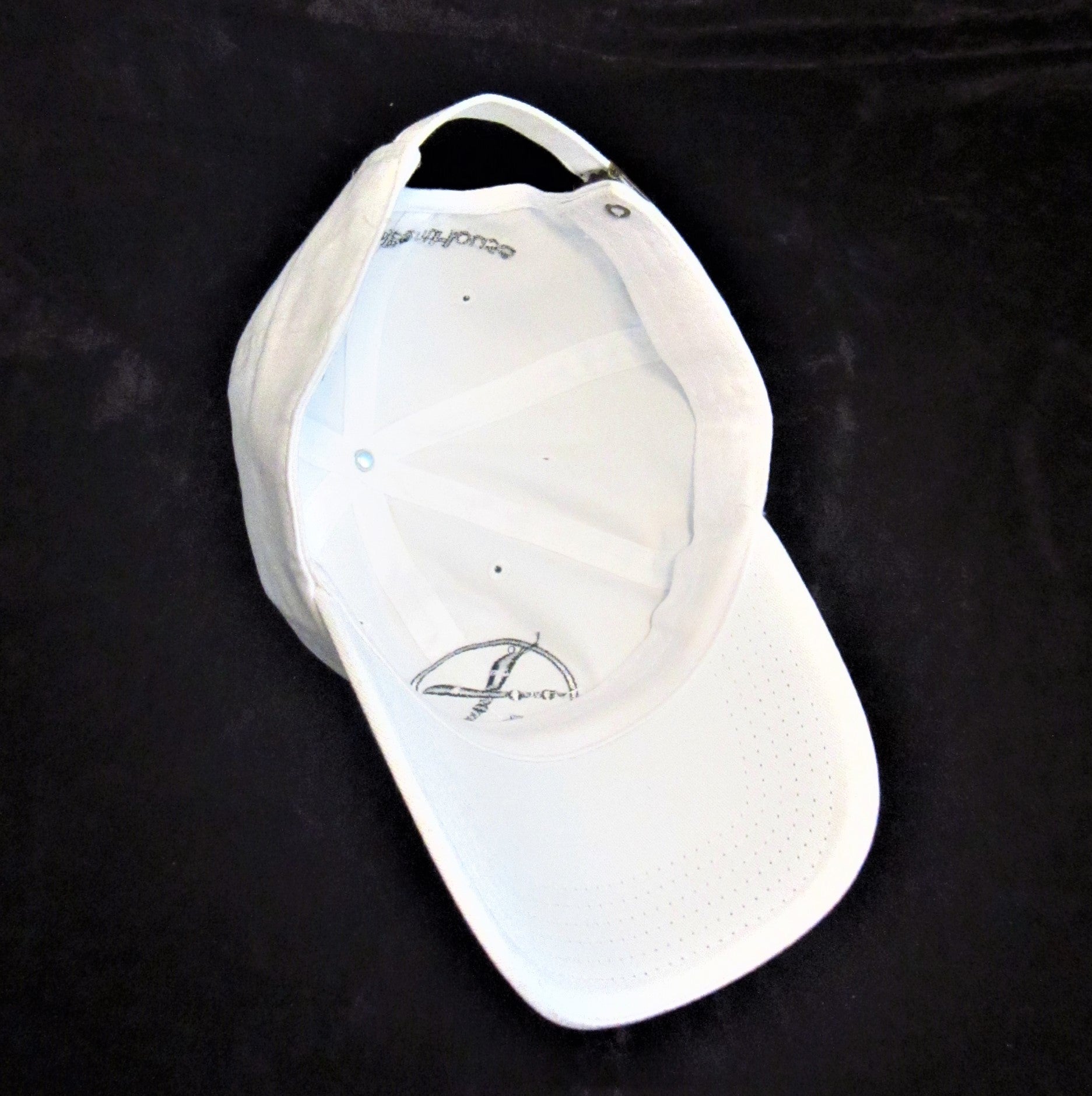 Inside of white baseball cap and visor.