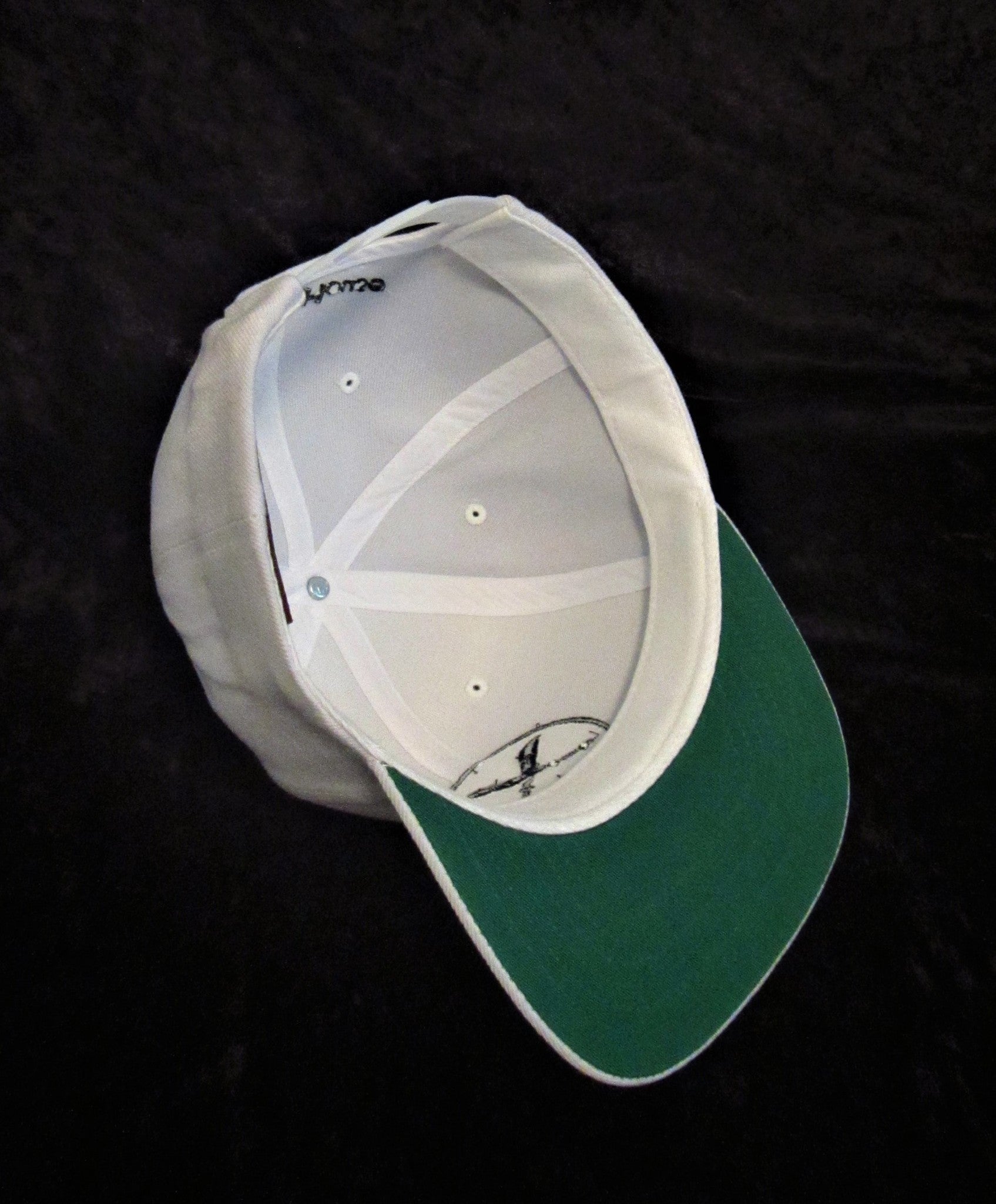 Inside White Flat Brim cap showing green underneath visor.