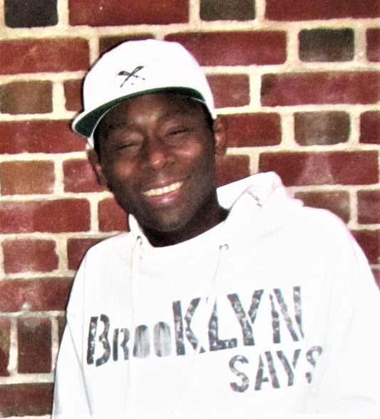 Man wearing White Flat Brim cap with Urban PentHouse logo embroidery in black.