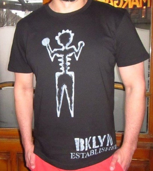 Close up of white hand-painted ambiguous person with Brooklyn established words on black tee shirt. 