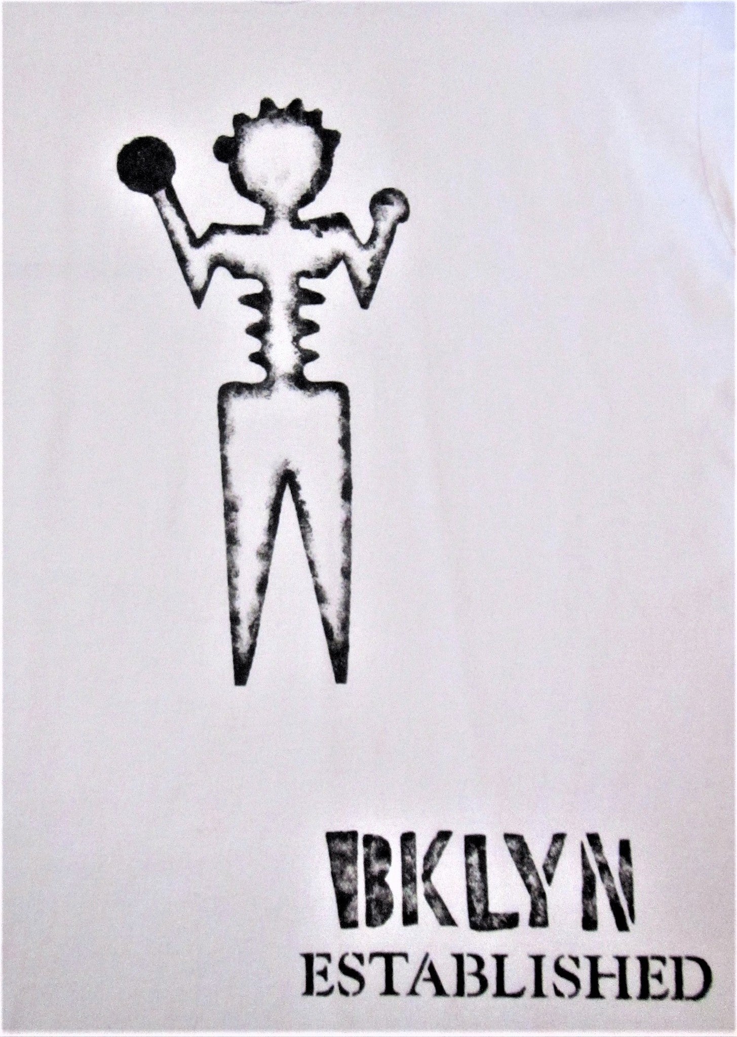 Close up of black hand-painted ambiguous person with Brooklyn established words on white tee shirt. 
